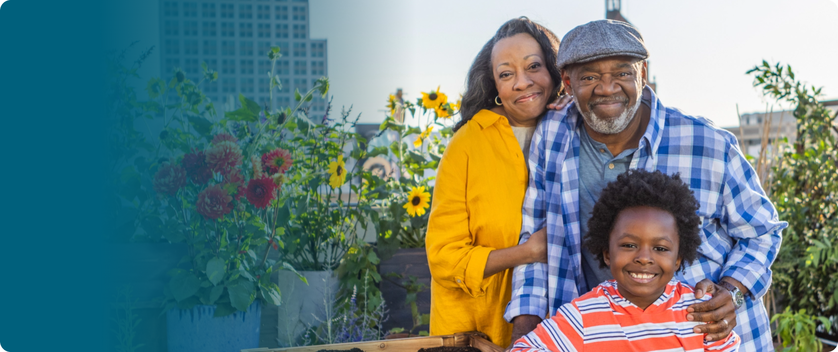 Actor portrayal of an older adult couple with their grandchild smiling at the camera