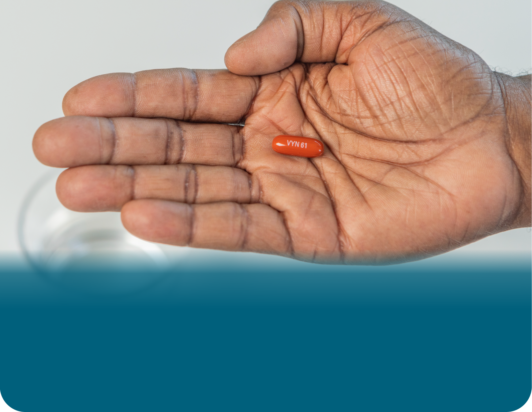 A hand with palm facing up holding a VYNDAMAX (tafamidis) pill